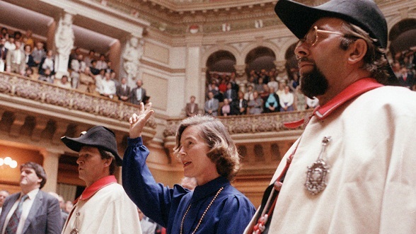 The first woman elected to the Federal Council: Accompanied by two clerks, Elisabeth Kopp raises her right hand to take oath at her swearing in in the National Council chamber on 2 October 1984.